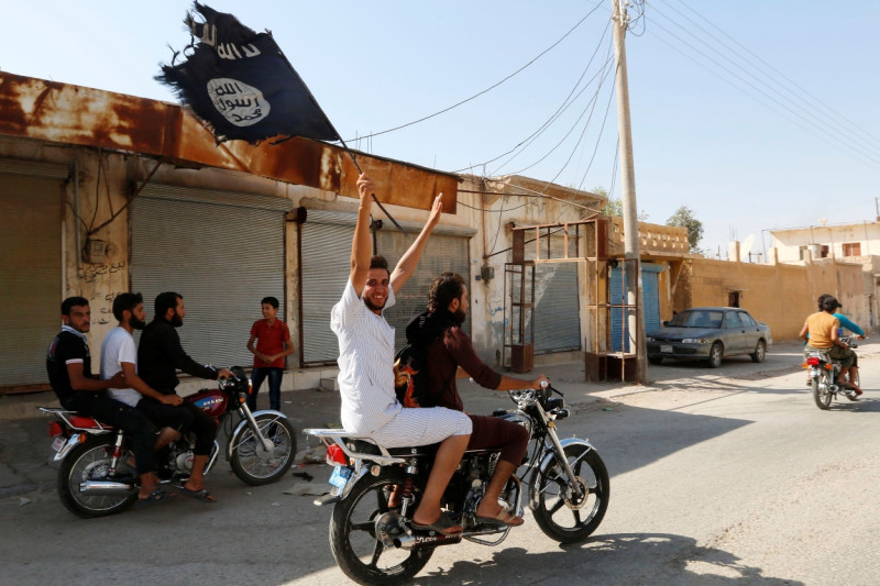 部分塔布卡居民高舉伊斯蘭國的旗幟，坐在摩托車上遊街，慶祝伊斯蘭國佔領了塔布卡的空軍基地。圖片來源：達志影像/路透社資料照片。   