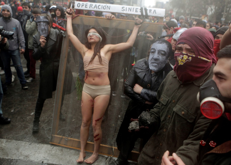 皮諾契在1973年到1990年間在智利實施獨裁統治，曾經殺害3千多人。圖為智利行動藝術家於2012年在街頭上演抗議當年獨裁政權者遭受凌虐的行動劇。圖片來源：達志影像/美聯社。   