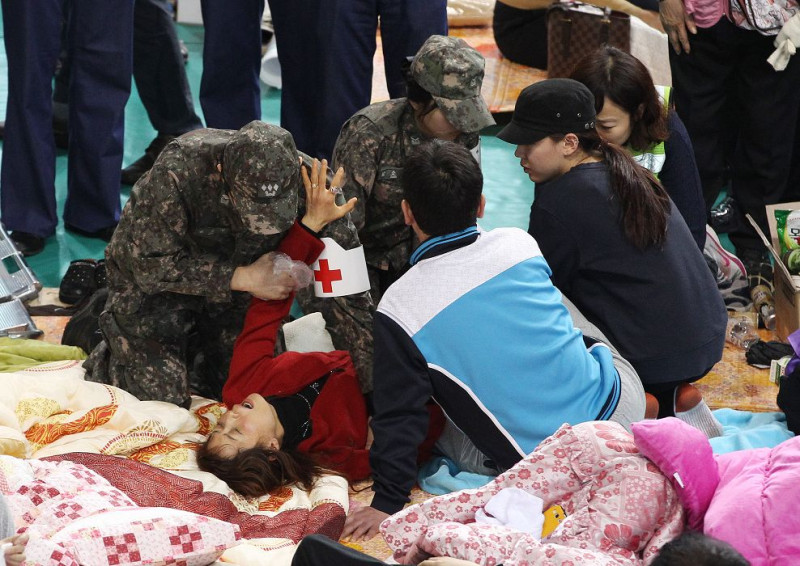 韓國發生重大的沉船意外，軍醫正在安撫悲痛欲絕的失蹤學生家屬。圖片來源：達志影像/美聯社   