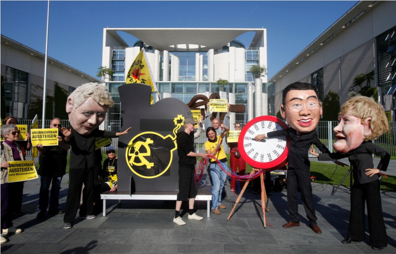 圖為德國總理梅克爾上週日與其他3個政黨開會協商，討論核電廠存廢的議題時，場外的反核團體也進行施壓動作。圖片來源：達志影像/路透社   