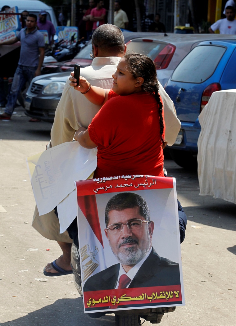 埃及被罷黜的首任民選總統穆西及其他14名伊斯蘭主義領導人，因去年12月涉嫌煽動暴力衝突遭起訴至刑事法院。圖為穆西支持者及其女兒。圖片來源：達志影像/路透社。   