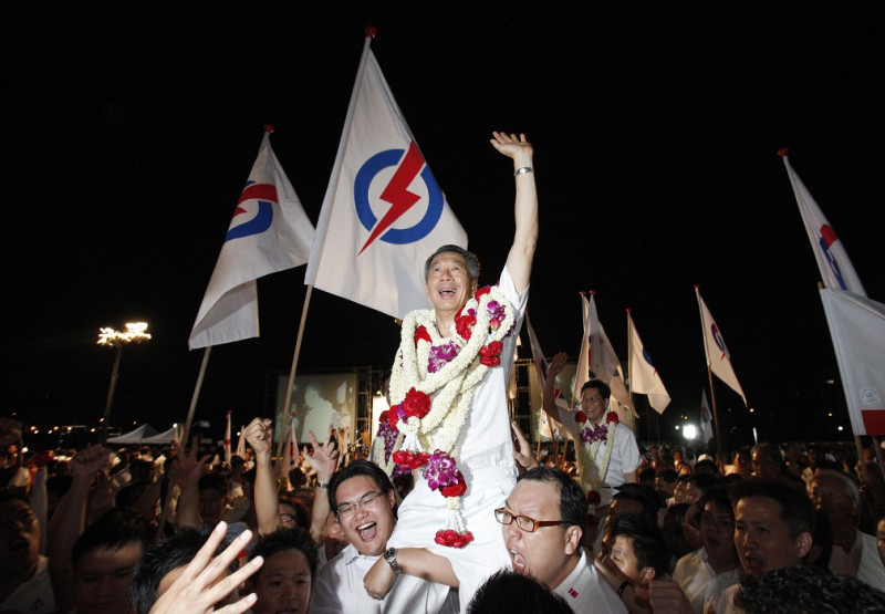新加坡總理李顯龍7日晚間在執政黨人民行動黨於集選區獲得勝利時，被支持者高高舉起。圖片來源：達志影像/路透社。   