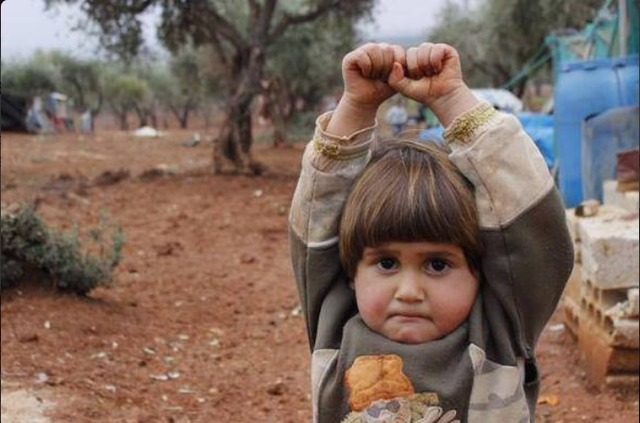 小女孩一見相機就舉雙手投降，而且瞪著大眼抿著小嘴巴，令人疼惜。圖：翻攝Nadia Abu Shaban推特   