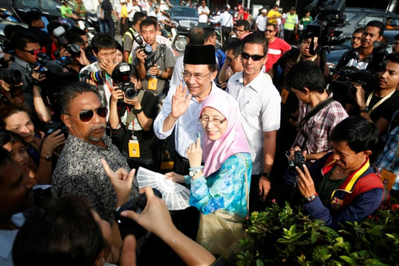 馬來西亞大選今天投票，在野黨領袖安華和他妻子投完票之後欲離去時，獲得許多支持者的擁護。圖片來源：達志影像/路透社   