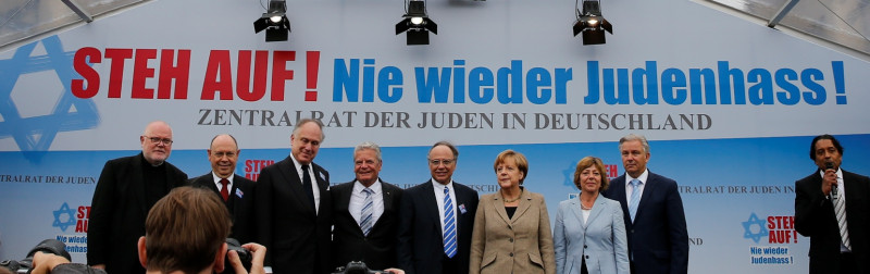 路透社14日報導，梅克爾所在集會背景布幕上的主題寫著：「起來！再也沒有仇恨猶太人！」(德語：STEH AUF! Nie wieder Judenhass!)圖片來源：達志影像/路透社。   