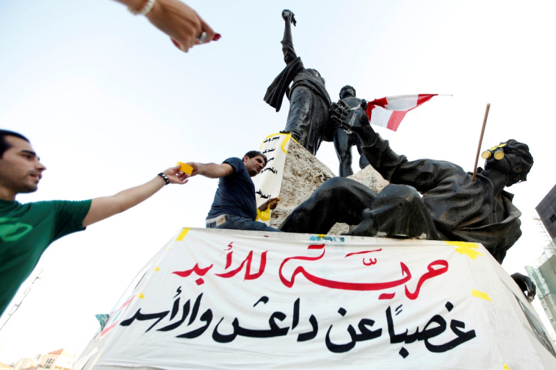圖為運動者在黎巴嫩貝魯特的烈士廣場紀念敘利亞化武攻擊一週年。標語上寫著：「永遠自由！怒對伊斯蘭國和阿薩德」。圖片來源：達志影像/路透社。   