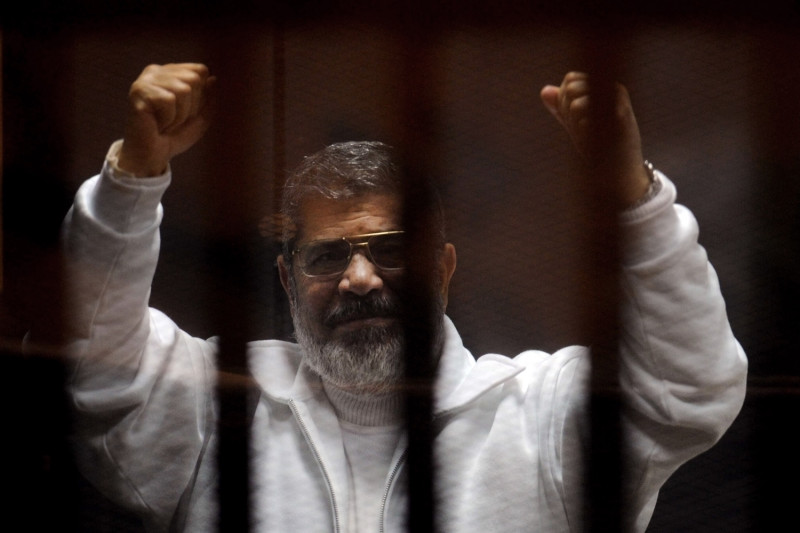 埃及前總統穆西3月出庭時，即使在牢籠中仍高舉雙手向人民致意。圖片來源：達志影像/美聯社   