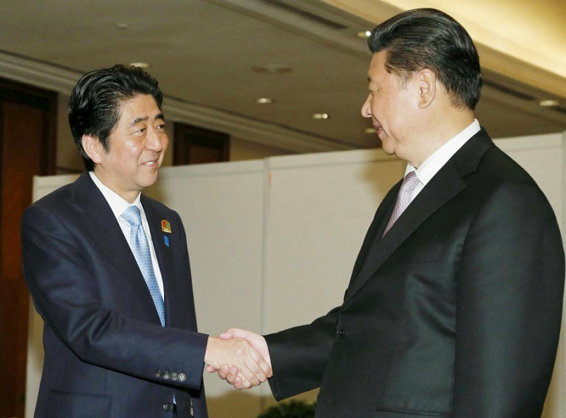 中國國家主席習近平和日本首相安倍晉三趁出席印尼亞非峰會，22日晚間舉行會談，2人在會談前握手。圖片來源：達志影像/路透社   