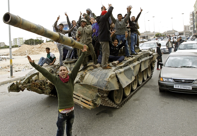 美國總統歐巴馬19日對利比亞領導人格達費（Moamer Kadhafi）發出最後通牒，要求格達費立即停止對反抗軍的攻擊行動，圖為一群反抗軍站在一台政府軍的戰車上擺出勝利姿勢。圖片來源：達志影像/路透社   