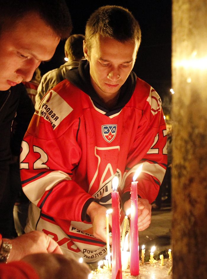 俄羅斯民眾點燃蠟燭紀念發生墜機意外的大陸冰球聯盟(KHL)「火車頭」隊(Lokomotiv Yaroslavl)的球員。圖片來源：達志影像/路透社。   
