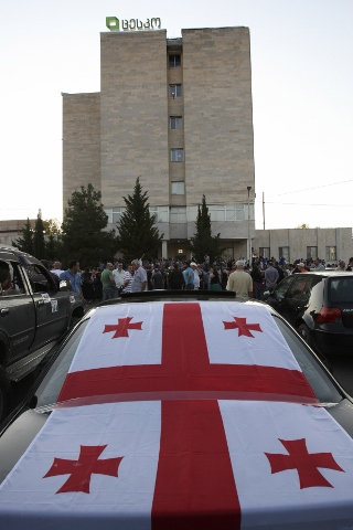 喬治亞可望首度政黨輪替，有人在車上覆蓋國旗，前往中央選舉機構關切。(圖片來源:達志影像/美聯社)   