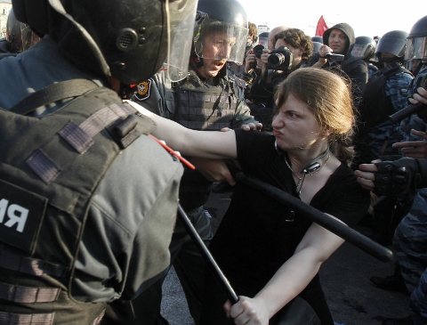 普亭（Vladimir Putin）明日就任俄羅斯總統，參與「百萬人行軍」抗議的一名女子，在莫斯科與鎮暴警察對抗。(圖片來源:達志影像/路透社)   