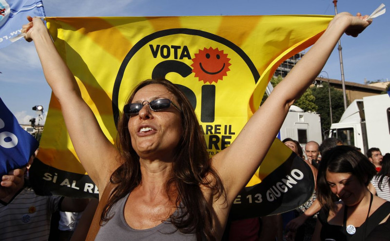 1名義大利婦女高舉反核旗幟走在羅馬市中心，慶祝廢核公投的勝利。圖片來源：達志影像/路透社。   