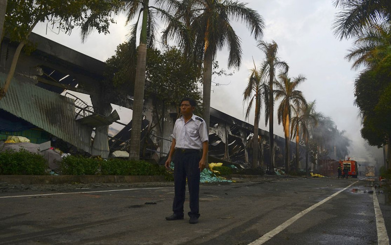 越南反中暴動遍地開花，許多台資工廠遭暴民縱火打劫，圖為一名廠區管理員14日無奈地看著遭焚毀的工廠。圖片來源：達志影像/路透社   