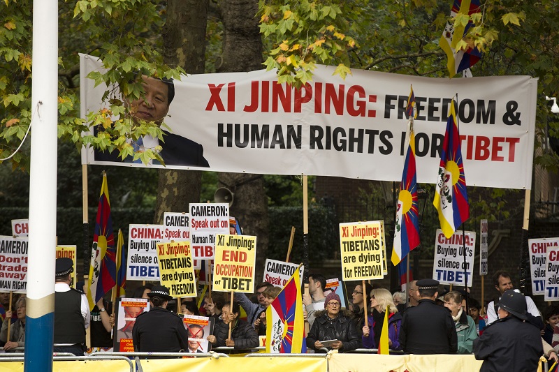人權團體與支持西藏的抗議人士揮舞抗議標語、高分貝抗議習近平訪問英國。圖片來源：達志影像/美聯社   