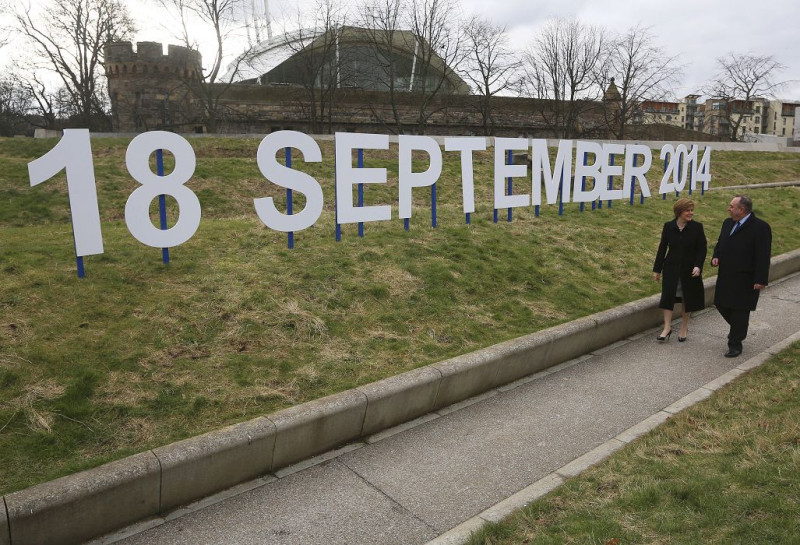 蘇格蘭地方政府首席部長、蘇格蘭民族黨領袖薩蒙德(Alex Salmond)21日走在蘇格蘭議會外，旁邊豎立著獨立公投時間的字牌。圖片來源：達志影像/路透社。   