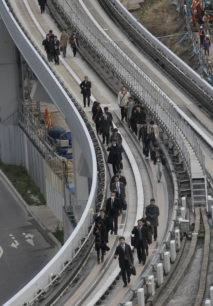 日本發生8.9級強震，在地震發生後，新幹線停駛，不少乘客沿著軌道疏散。圖片來源：達志影像/美聯社。   