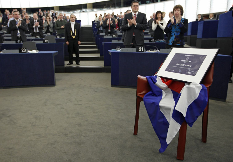 歐洲議會議員對著一張覆蓋古巴國旗、放著2010歐盟沙卡洛夫（Sakharov）人權獎證書的空椅子鼓掌，因人權獎得主古巴記者法里納斯未獲古巴官方旅行許可，無法出席頒獎典禮。圖片來源：達志影像/路透社。   