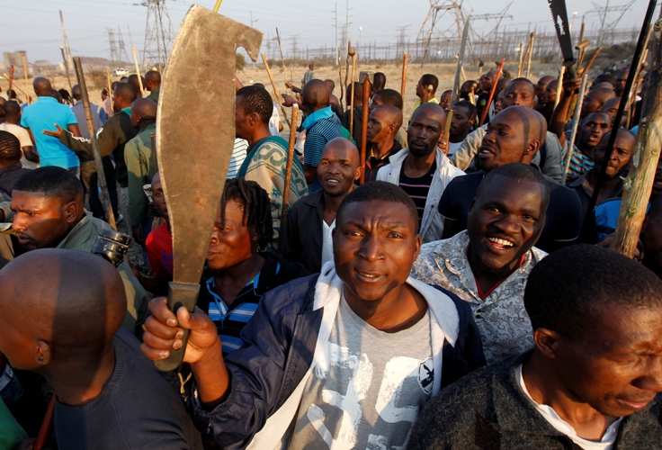 南非16日爆發嚴重警民衝突，造成數十名礦工死亡。這場突發性罷工抗議由超過3000名礦工發起，群眾高舉棍棒、砍刀等武器準備戰鬥，要求提高薪資。圖片來源：達志影像/路透社。   