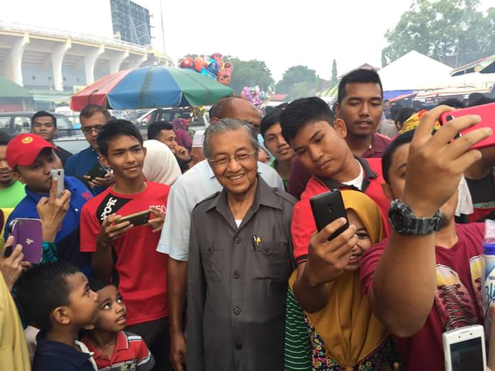 馬來西亞前總理馬哈迪（中穿灰衣者）高齡已90歲，仍擁有高人氣，年輕粉絲紛紛合影。圖：翻攝馬哈迪臉書   