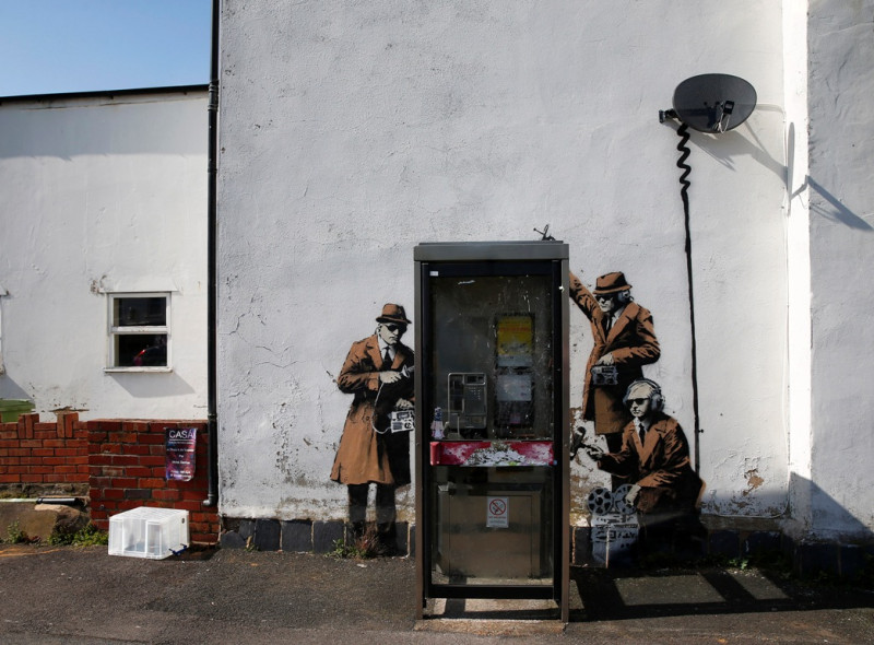 街頭藝術家在英國情報機關「政府通訊總部」(GCHQ)的外牆塗鴉，諷刺他們監聽電話。圖片來源：達志影像/路透社。   