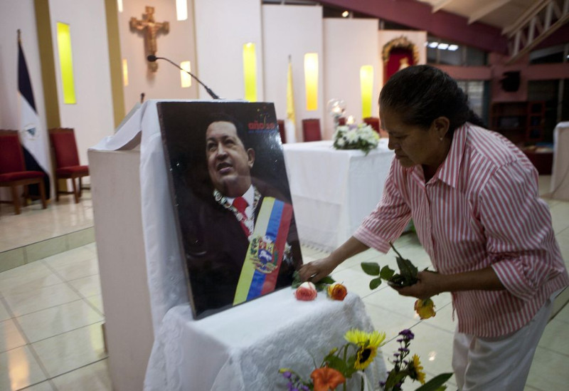 委內瑞拉總統就職大典將於10日舉行。連任成功的查維茲(Hugo Chavez)卻仍在古巴的醫院病榻上與癌症搏鬥，無法返國宣誓。圖為民眾在查維茲肖像前獻花致意。圖片來源：達志影像/美聯社。   