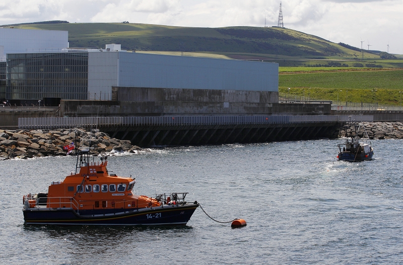 28日蘇格蘭的托尼斯核電廠遭水母堵塞進水口，圖中右方的漁船正用拖網清除進水口附近的水母，後方則是托尼斯核電廠的建築本體。圖片來源：達志影像/路透社   