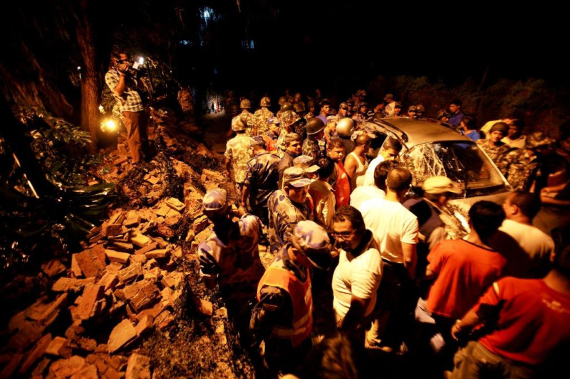 印度、尼泊爾邊界18日晚間發生一起芮氏規模6.9的強震，圖為尼泊爾軍方在英國大使館圍牆倒塌之處，救援被壓倒受損的汽車及可能在裡面的傷者。圖片來源:達志影像/路透社   