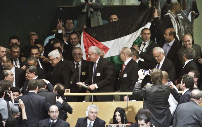 聯合國大會在「聲援巴勒斯坦人民國際日」這一天，通過決議將巴勒斯坦目前在聯合國享有的「觀察員實體」地位，提升至「觀察員國地位」。圖為巴勒斯坦代表興奮地在場中展開國旗。圖片來源：達志影像/美聯社   