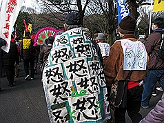 東京反核大集會11日在代代木公園舉行，1位身上披著寫滿「怒」字毯子的山田先生，激動地表示「我說不出話來，真的很丟臉，很難過」。圖片來源：中央社   