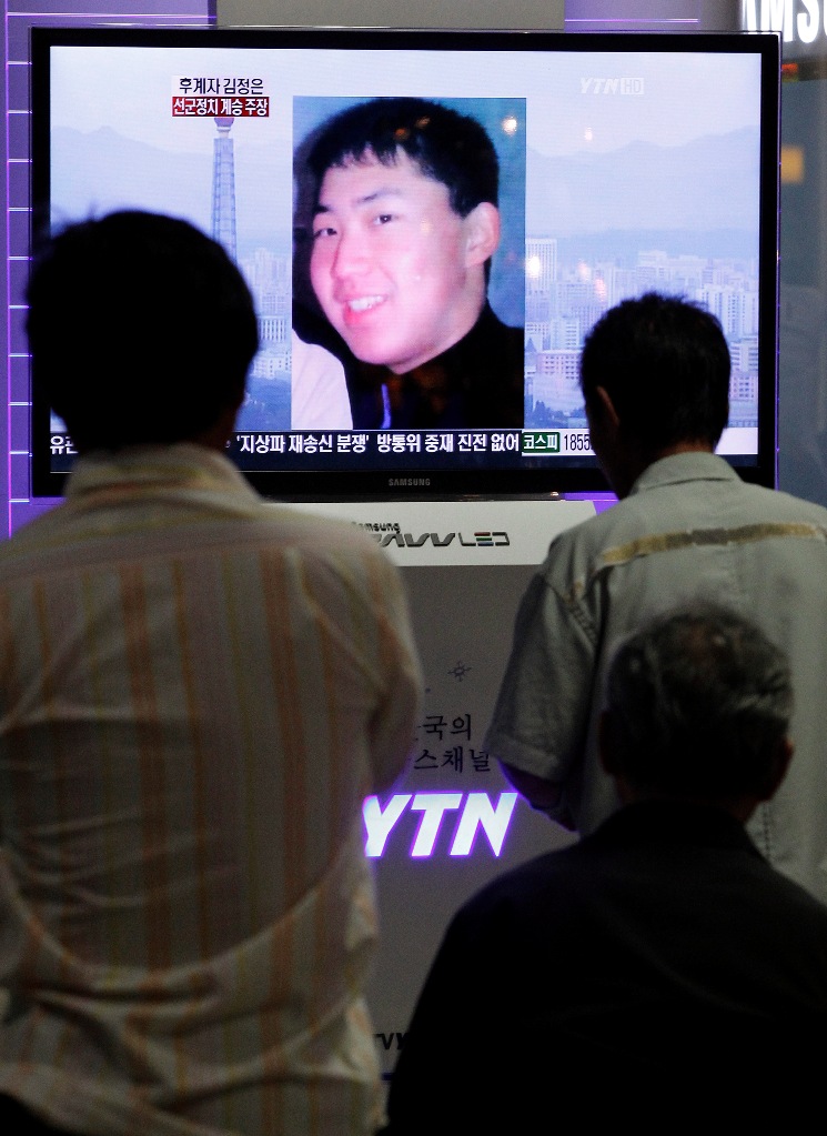 南韓民眾在街頭上，盯著電視看金正銀的新聞。圖片來源：達志影像/路透社。   