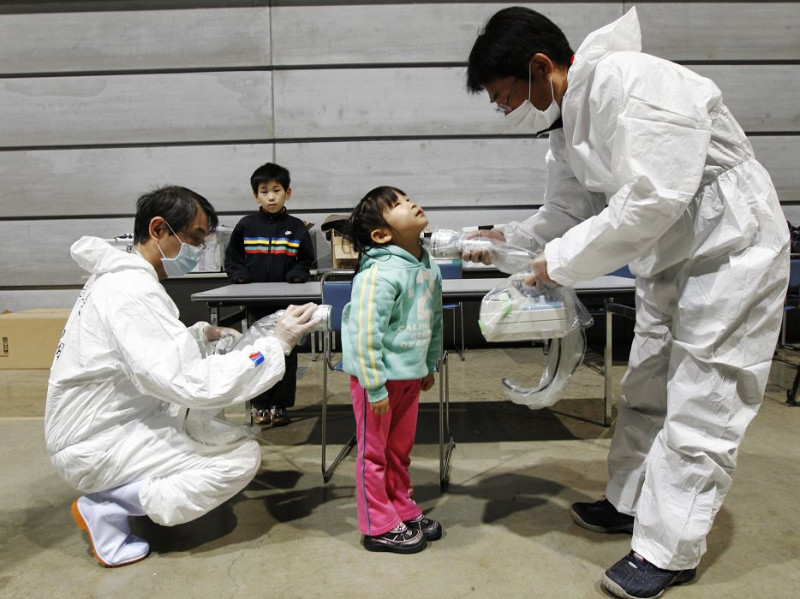 在距離福島第一核電廠70公里處的郡山（Koriayama）一處疏散所，一名5歲的幼童正在接受輻射量檢測。圖片來源：達志影像/路透社。   
