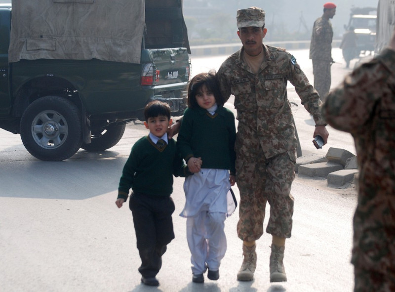 塔利班武裝份子今（16）日闖入巴基斯坦白夏瓦（Peshawar）地區一所軍隊公立學校開火，造成超過100人死亡。圖為安全部隊護送學生離開。圖片來源：達志影像/路透社   
