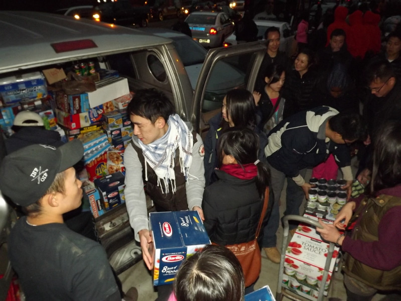 志工們將裝滿整部箱型車的救援物資卸下，送到社區活動中心。圖：NYDECO/攝。   