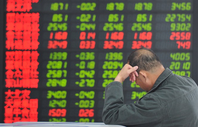 9月30日上海股市下跌，一位投資人無奈地坐在螢幕前嘆息。圖片來源：達志影像/美聯社。   