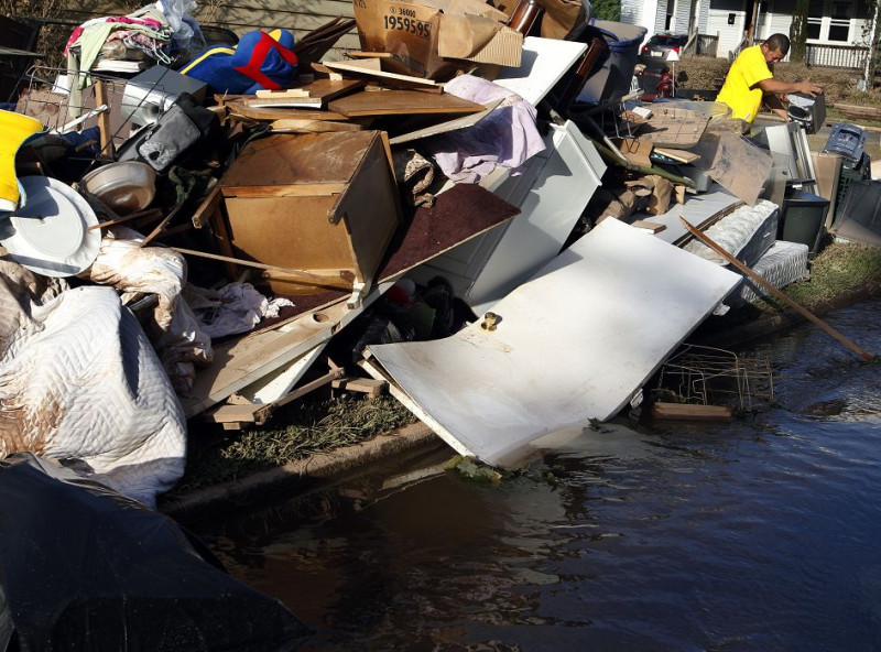 居住在美國紐澤西州的民眾正在清理因艾琳颱風被洪水侵襲的家園。圖片來源：達志影像/美聯社。   