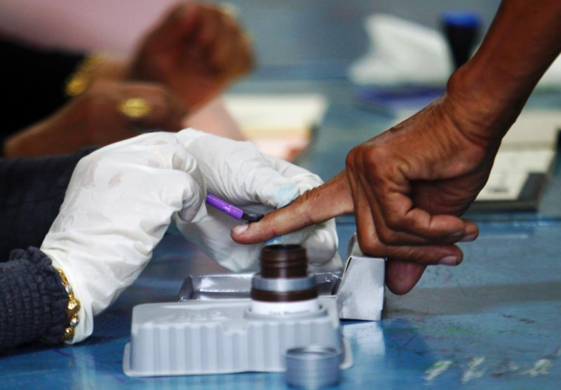 馬來西亞大選今天舉行投票，投票後，選務人員會為投票者的指甲塗上持久的色印，以顯示已經投過票。圖片來源：達志影像/路透社   