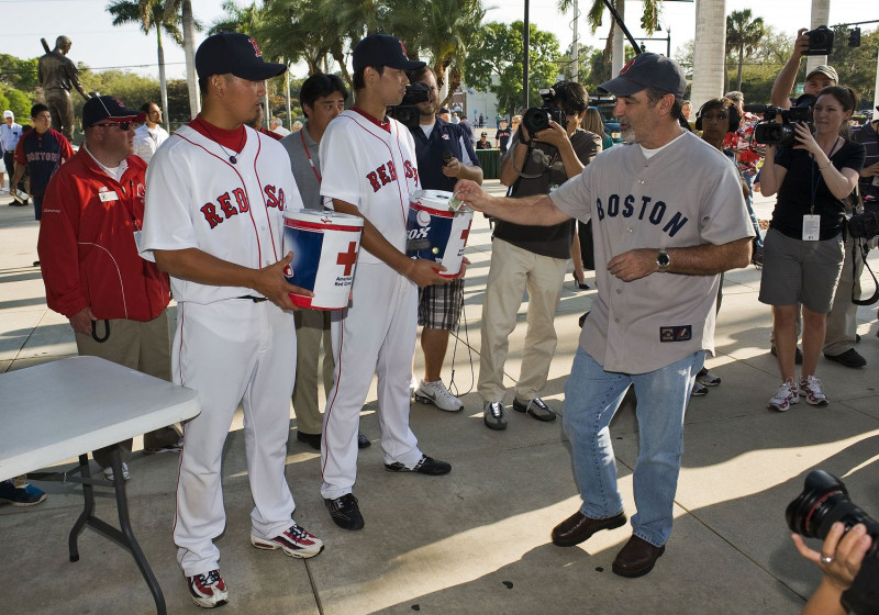 波士頓紅襪隊日本球員松坂大輔等在美國佛羅里達州拿著紅十字會的募款箱，為日本強震後的救災工作進行募款行動。圖片來源：達志影像/路透社。   