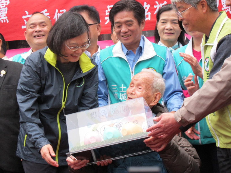 民進黨總統候選人蔡英文11日在三峽祖師廟回紀念版贈108歲人瑞林（不直）阿公3隻小豬撲滿。圖：林朝億/攝   