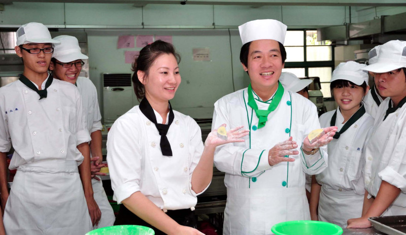 民進黨大台南市長候選人賴清德（左四）廿三日與育德職校學生一起製作糕點，他勉勵學生適性發展，習得一技之長，有助於立足社會。圖片：陳衍有攝   