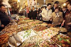總統馬英九（前右3）8日一早陪同母親秦厚修（前右2）前往台北市興隆市場，採買年夜飯食材。圖片來源：中央社   