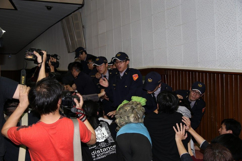 民眾在主席台後方阻擋警方進入，最後民進黨立委擋在門口，警察不敢再往前。圖2之2：林雨佑/攝   