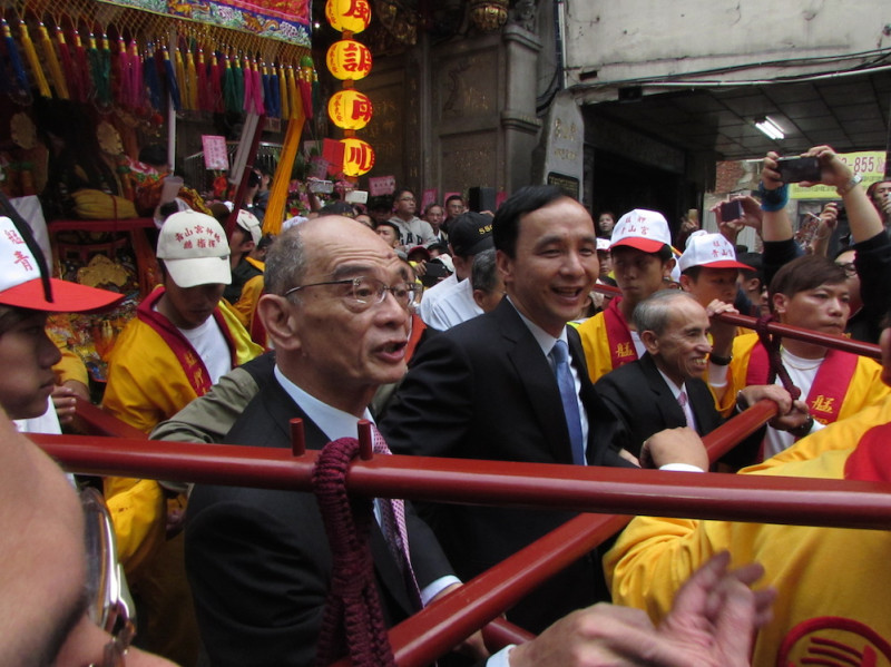 國民黨總統候選人朱立倫2日下午出席艋舺青山宮的靈安尊王聖誕千秋祭祀活動，親自示範抬轎。圖：邱珮文/攝   