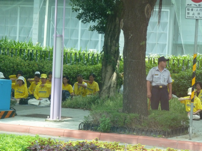 第8次江陳會9日登場，有逾百位法輪功人士在中山北路上以打坐練功之姿，在大熱天席地而坐，進行靜默的抗議活動。圖：謝莉慧/攝   