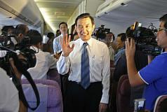 總統馬英九（中）11日進行「賀誼專案」，出訪邦交國巴拉圭，在飛機上向隨行團員揮手致意。圖：中央社   