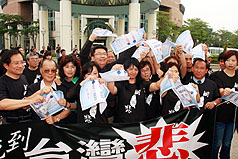 總統馬英九19日再釋出南台利多，但民進黨台南市黨部及市議會黨團上午在市議會前廣場發動靜坐抗議，批評馬英九之前對台南的承諾跳票，並撕毀當年馬英九的競選文宣。圖片來源：中央社   