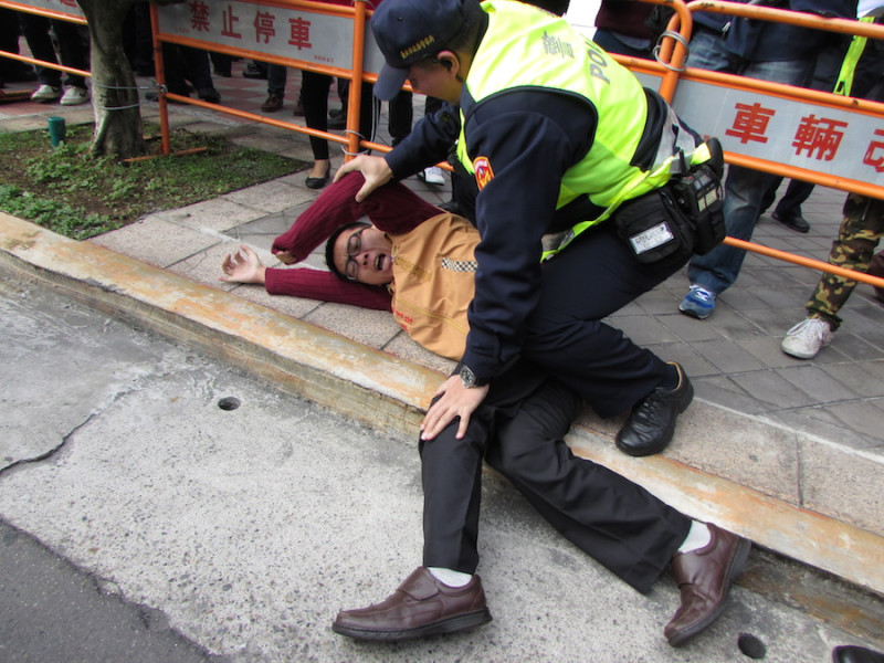 兩岸企業家峰會今(15)天在台北國際會議中心舉行，台聯組織部副主任張兆林試圖衝入會場抗議，卻遭警方制服在地。圖：邱珮文/攝   
