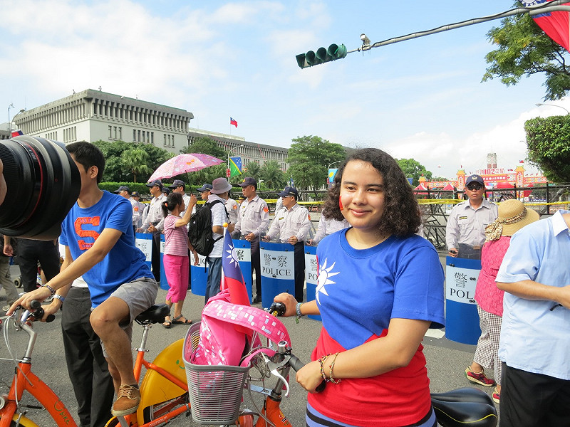 1位法籍女子與友人騎著腳踏車，穿著國旗裝在凱道前開心的拍照留念。圖：林朝億/攝影&nbsp;&nbsp;&nbsp;