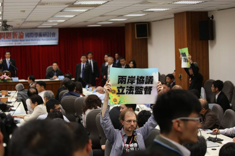 場內也有中研院近代史研究所研究員陳儀深和另一位學者，先後舉起有太陽花圖案並寫著「台灣未來 人民做主」、「兩岸協議 立法監督」的標語。圖3之2：林雨佑/攝   