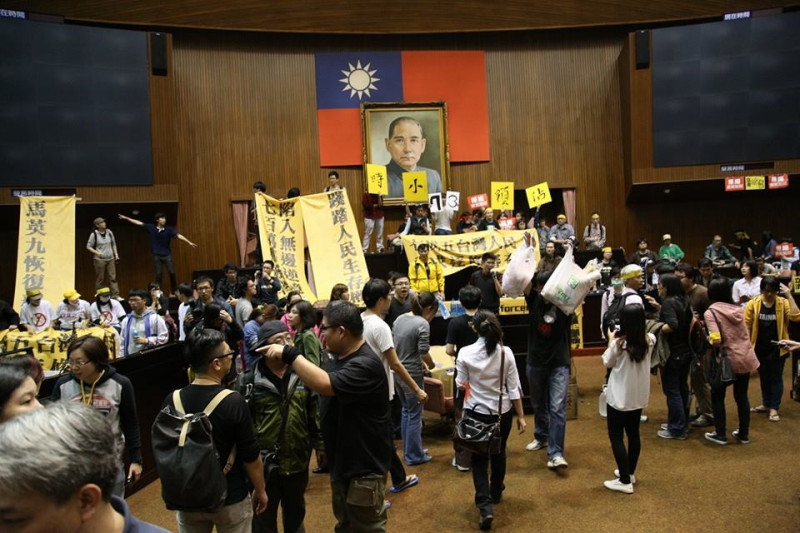 上百名反服貿學生今(18)晚衝進立法院並佔據議場主席台，表達對立院審查服貿過程粗糙的不滿，並高喊「把議場還給人民」。圖：林雨佑/攝   